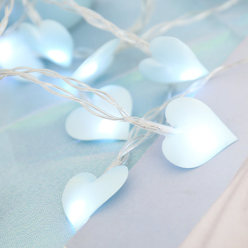 Heart-shaped string lights on a soft blue background