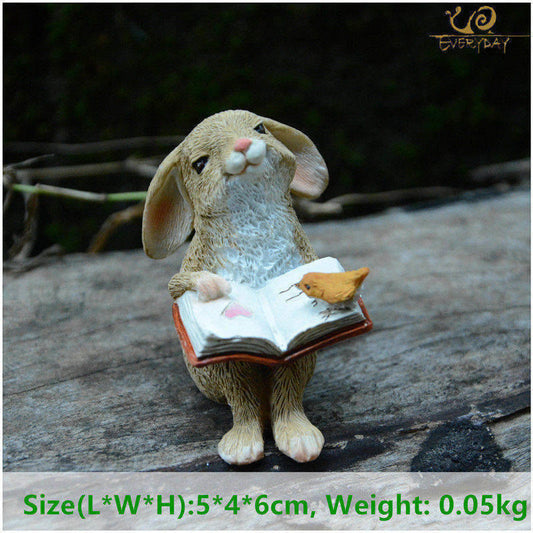Small rabbit figurine reading a book with a bird tabletop or garden decoration