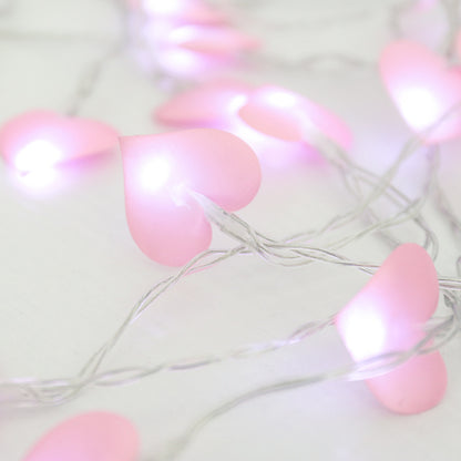 String of pink heart-shaped lights on a white background