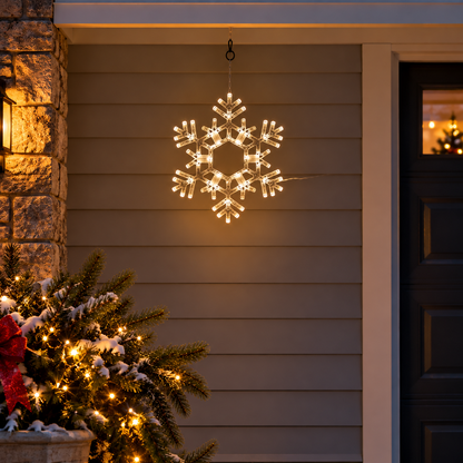 20-inch Kringle Traditions folding Christmas snowflake with 70 steady warm white LED lights hanging on a decorated front porch at night