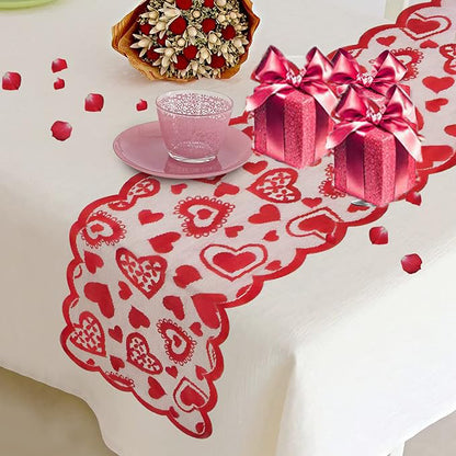 Decorative tablecloth with heart patterns, a gift box, and a teacup on a white surface.