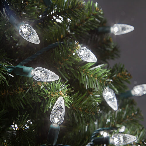 Cool white C6 Strawberry LED Christmas string lights on green wire displayed on a Christmas tree