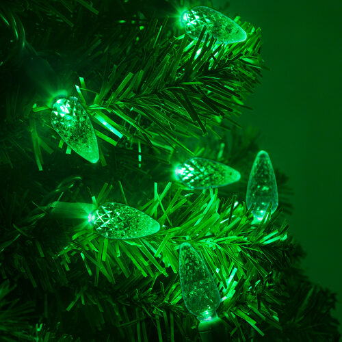 Green C6 Strawberry LED Christmas string lights glowing on a Christmas tree