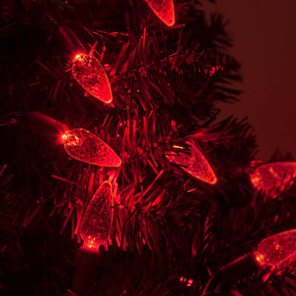 Red C6 Strawberry LED Christmas string lights glowing on a Christmas tree