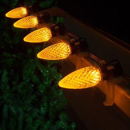 Gold C9 OptiCore LED Christmas string lights on green wire