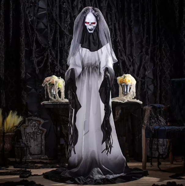 Halloween decoration of a ghostly figure in a white gown with black accents, standing in a dark, eerie setting.
