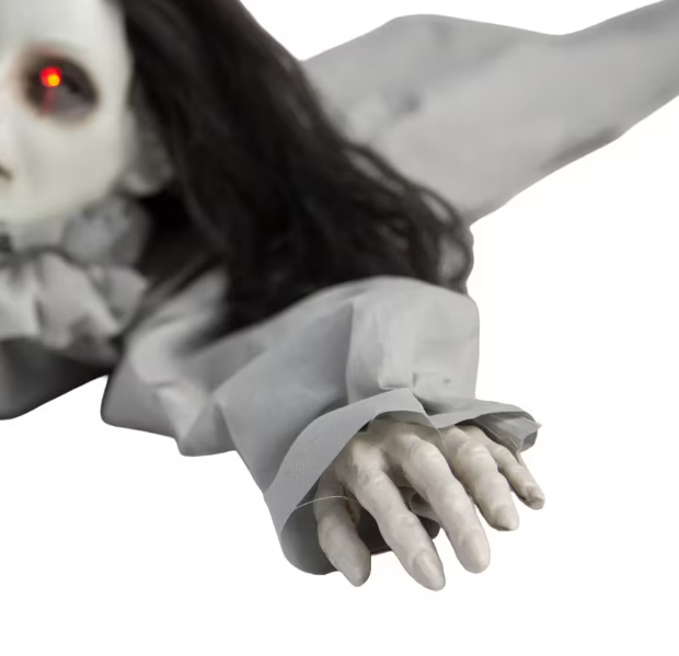 Horror-themed doll with glowing red eye and outstretched arm 