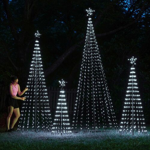 Cool white animated LED Christmas light show trees in multiple heights displayed outdoors at night with person for scale.