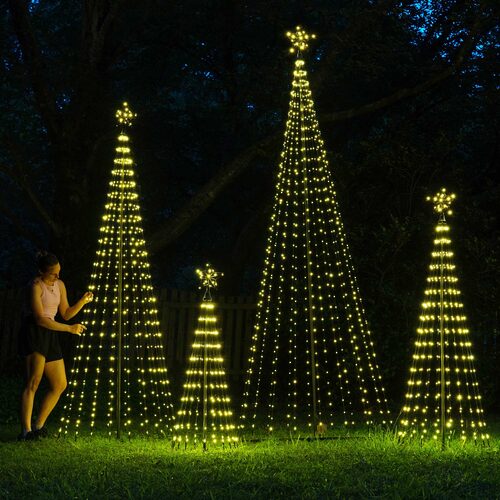 Wintergreen Lighting warm white animated LED Christmas light show trees in multiple sizes displayed outdoors with glowing star toppers.