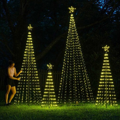 Wintergreen Lighting warm white animated LED Christmas light show trees in multiple sizes displayed outdoors with glowing star toppers.