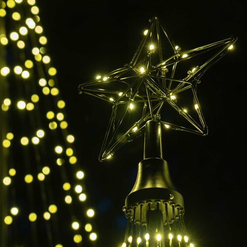 Wintergreen Lighting warm white animated LED Christmas light show trees in multiple sizes displayed outdoors with glowing star toppers. 