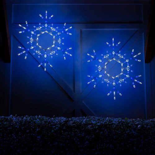 Two matching 36-inch blue and cool white LED folding snowflakes illuminated together in an outdoor Christmas decorating display.